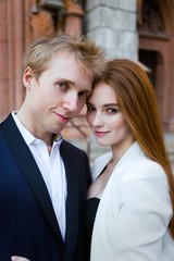 fashion portrait of beautiful young couple posing outdoors