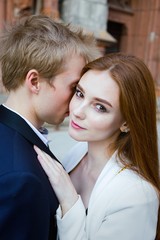 fashion portrait of beautiful young couple posing outdoors