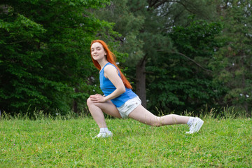 Naklejka na ściany i meble a girl is doing sports exercises in the park