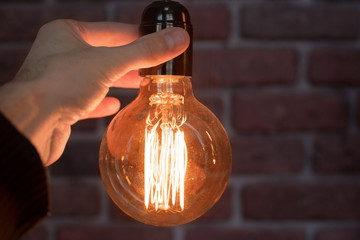 Decorative antique edison style light tungsten bulbs against brick wall background