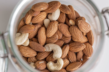 Almonds and cashews in a glass jar.
