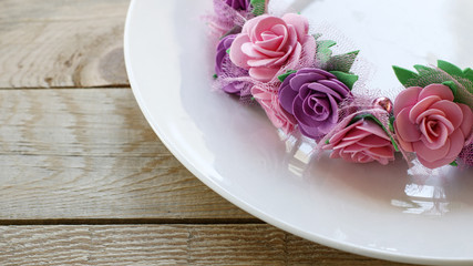 Wedding table decoration: a wreath of flowers on a white plate