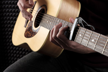 Fototapeta na wymiar Close photo of the guitar playing male hands.
