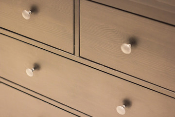 a wooden wardrobe drawer front, metal handle
