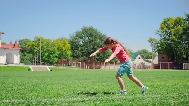Beautiful girl makes a wheel. Girl of eight years old on the green grass makes a wheel at extreme slow-motion shot