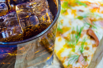 Delicious pizza with a glass of cold Cola with ice.