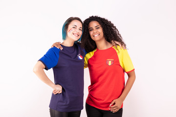 Fototapeta na wymiar Portrait de deux jeunes supportrices de l'équipe d'Espagne et de l'équipe de France fraternisant