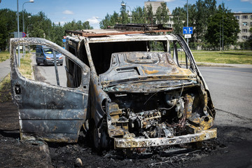 Fully burned minivan on the city road