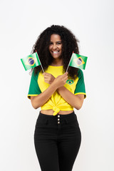 Portrait d'une jeune supportrice de l'équipe du Brésil tenant deux petit drapeaux  - obrazy, fototapety, plakaty