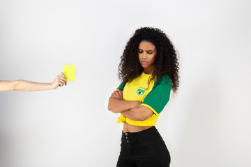 Portrait d'une jeune supportrice de l'équipe du Bresil prenant un carton jaune - obrazy, fototapety, plakaty