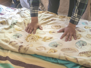 close up hands on a new bed textile blanket