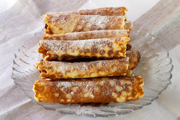 Waffles made from short dough, sprinkled with powdered sugar on a glass plate.