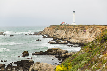 Fototapeta na wymiar Point Arena lighthouse perched on rocky cliff in Mendocino, California