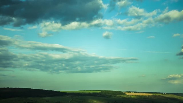 Quickly floating clouds over the field at day