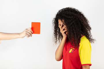 Portrait d'une jeune supportrice de l'équipe d'Espagne prenant un carton rouge - obrazy, fototapety, plakaty