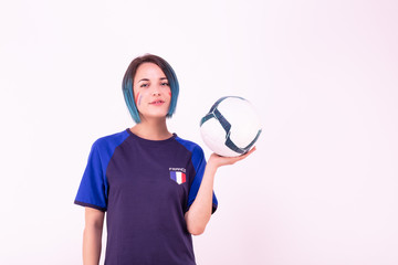 Portrait d'une jeune supportrice de l'équipe de France de football tenant un ballon dans ses mains