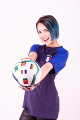 Portrait d'une jeune supportrice de l'équipe de France de football tenant un ballon dans ses mains