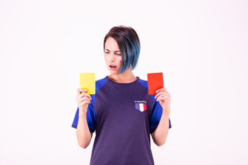 Portrait d'une jeune supportrice de l'équipe de France de football face à un carton jaune et rouge - obrazy, fototapety, plakaty