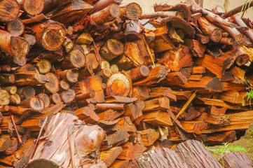 Chopped firewood on a stack, prepared for winter in a pile, natural wooden background
