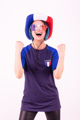 Portrait d'une jeune supportrice de l'équipe de France de football portant un chapeau et des lunettes tricolore - obrazy, fototapety, plakaty