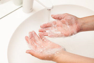 close up photo of woman washes her hands with soap and water
