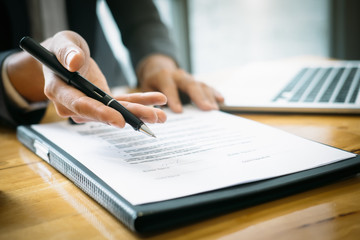 Close up business man reaching out sheet with contract agreement proposing to sign.Full and accurate details, individual who owns the business sign personally,director of the company, solicitor.