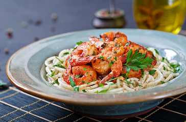 Pasta spaghetti with shrimps, tomato and chopped parsley. Healthy food. Italian meal.