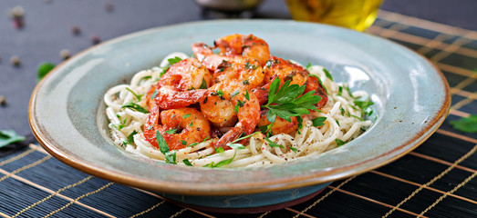 Pasta spaghetti with shrimps, tomato and chopped parsley. Healthy food. Italian meal. Banner