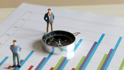 Compass and two miniature men on the chart