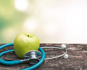 World health day, Eat an apple a day, keep doctor away concept with green natural nutrient apple with doctor's stethoscope in heart love shape