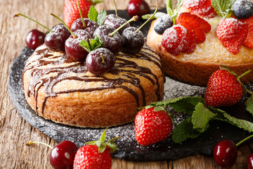 Dessert cakes with chocolate, mint, strawberries, cherries and blueberries close-up. horizontal