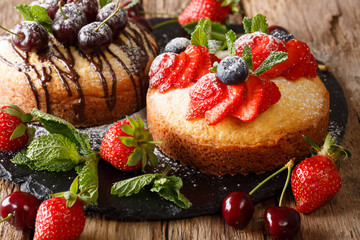 Delicate cakes with chocolate, mint and strawberries, cherries and blueberries close-up. horizontal
