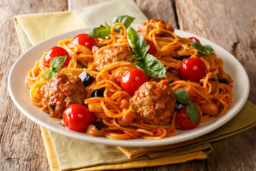 Delicious dinner: meat balls with pasta spaghetti, eggplant and tomatoes close-up on a plate. horizontal