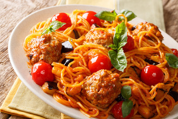Homemade meat balls with spaghetti, aubergines and tomatoes close-up. horizontal