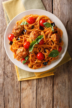 Homemade meat balls with spaghetti, aubergines and tomatoes close-up. Vertical top view