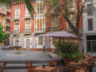 little hidden square with benches in the shade and tables of a romantic café, Alicante Spain