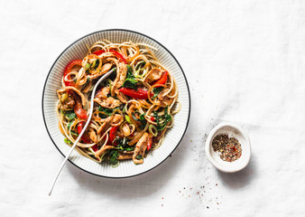 Teriyaki chicken, bell peppers, onions, spinach and rice noodles stir fry on white background, top...