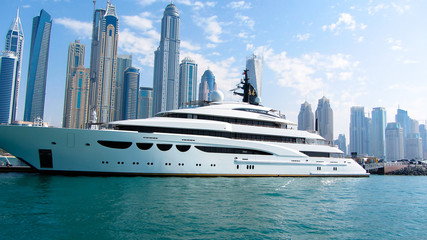 Yacht in dubai marina in front of high-rise buildings on 26th November 2016 - obrazy, fototapety, plakaty
