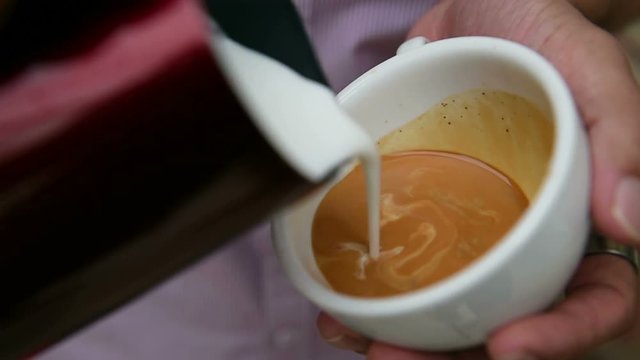 making a cup of latte art coffee