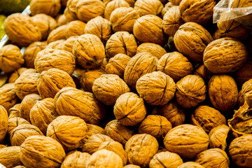 Walnut background, Walnuts on display at the farmer's market. Brown walnuts textured background