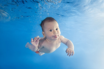 Fototapeta na wymiar little girl dives underwater in the pool