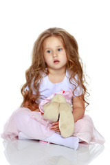 Little girl is sitting on the floor.