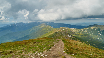 Panorama of green hills and stone road in Carpathian mountains in the summer. Mountains landscape background. Nature beauty