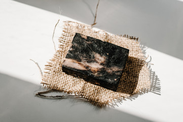Natural cosmetics: beautiful, fragrant black handmade natural spa soap on a white background isolated. Place for text and advertising. Sunlight. Soap bars closeup. Spa. flat lay. top view.