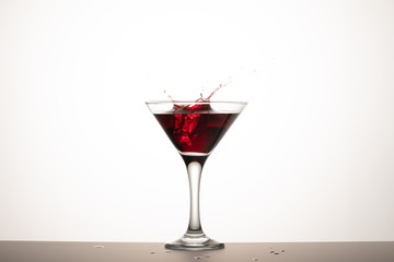 A piece of ice fell into a glass of wine.