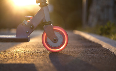 Pink kick scooter at sunset