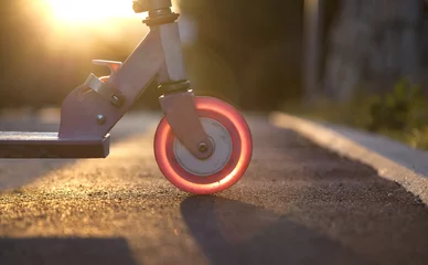 Cercles muraux Scooter Pink kick scooter at sunset