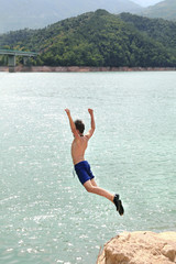 Fototapeta na wymiar Boy jumping into the water 