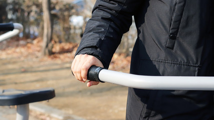 Obraz premium Exercise&nbsp;and&nbsp;health.&nbsp;Hands&nbsp;holding&nbsp;on&nbsp;to&nbsp;the&nbsp;grip&nbsp;of&nbsp;an&nbsp;exercise&nbsp;device