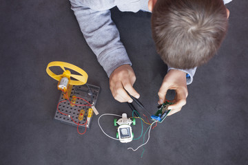 Boy building up an electronic robot